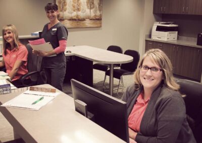 three ladies smiling at the reception desk