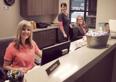 three ladies smiling at the reception desk